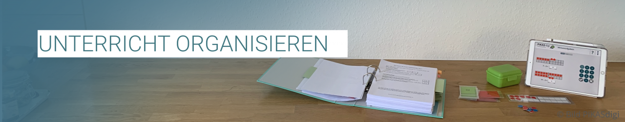 „Unterricht organisieren“ Tablet und Ordner mit ausgedruckten Materialien auf dem Tisch